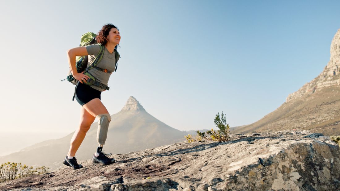 A person hiking on a mountain trail with a prosthetic leg