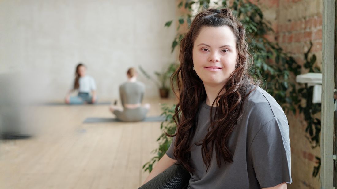 A member in a bright studio space, sitting and smiling