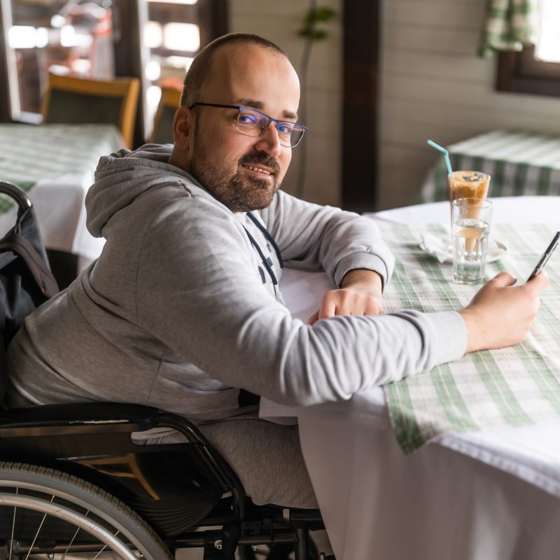 A member relaxing at a cafe table with a drink